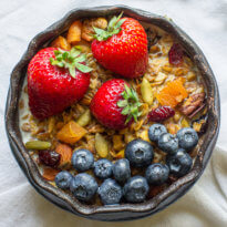 Homemade Granola with strawberries and blueberries in a bowl.