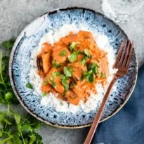 Chicken tikka masala on a blue plate with a fork.