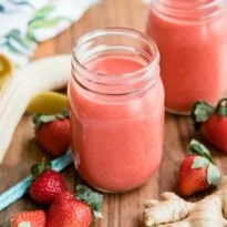 Strawberry citrus ginger smoothie in a clear mason jar.