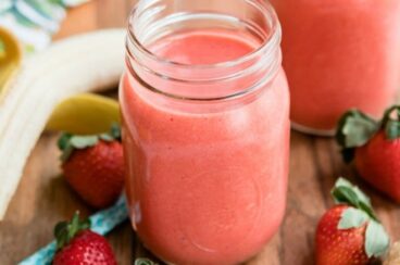 Strawberry citrus ginger smoothie in a clear mason jar.