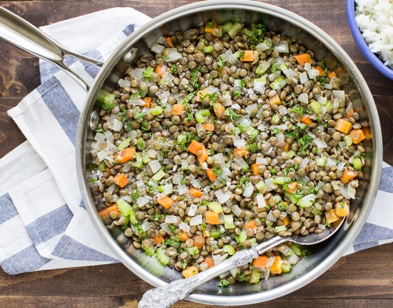Lentils and vegetables in a silver pan.