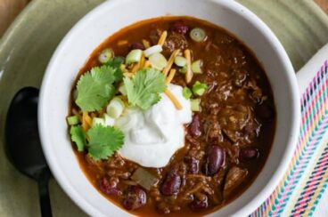 Slow cooker chili con carne in a white bowl.