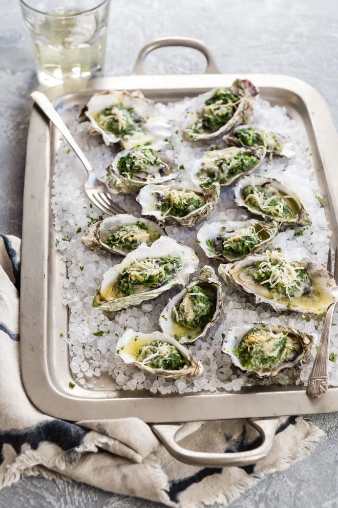 Oysters Rockefeller on a silver pan.