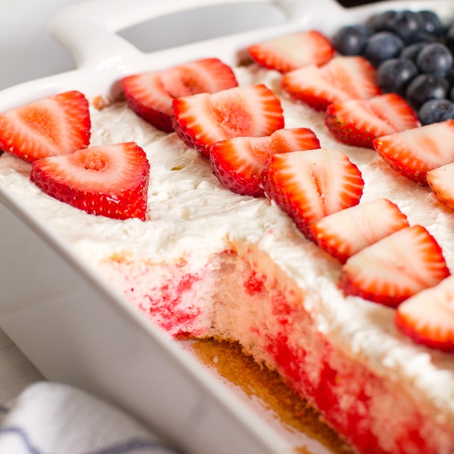 Strawberry Jello Poke Cake in a white dish. 