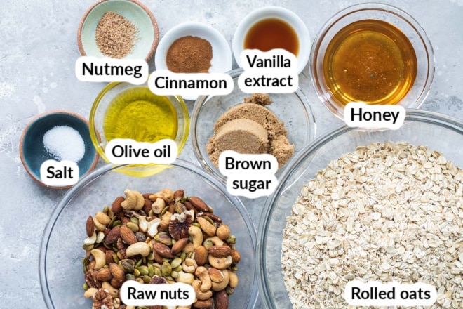 Labeled granola ingredients in various bowls.