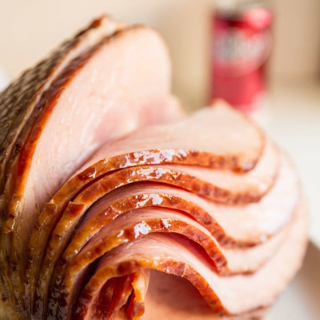  Dr. Pepper Ham spirally cut and five of the slices are stacked to the right while still attached to the bone.