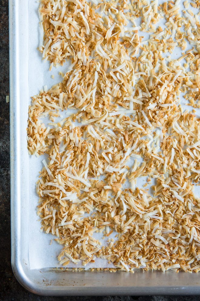Shredded toasted coconut on a baking sheet.