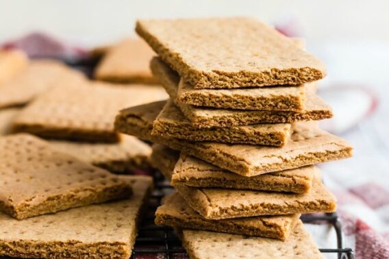 Homemade graham crackers stacked on a cooling rack.