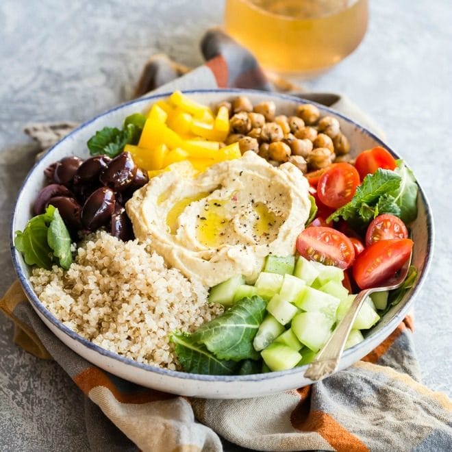 This easy Mediterranean Buddha Bowl is full of colorful veggies, nutritious quinoa, and roasted chickpeas. Top with hummus for an epic power lunch!