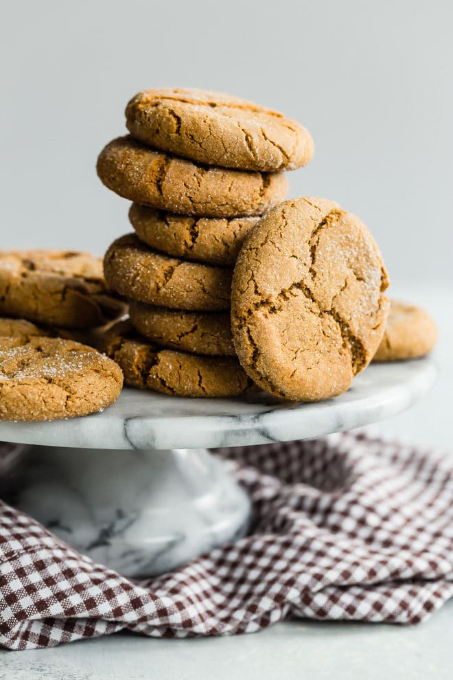 Molasses cookies in a stack on a gray cake plate.