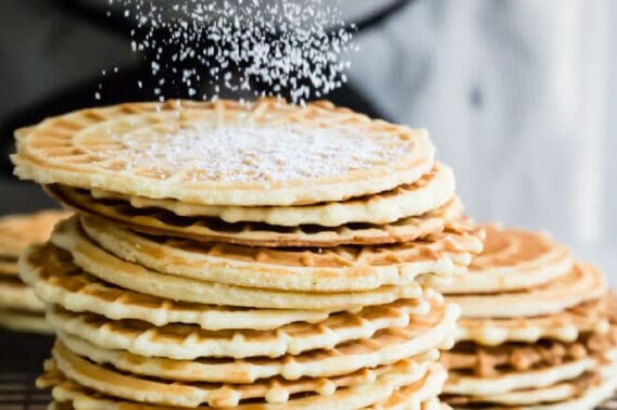 Pizzelles stacked on a cooling rack.