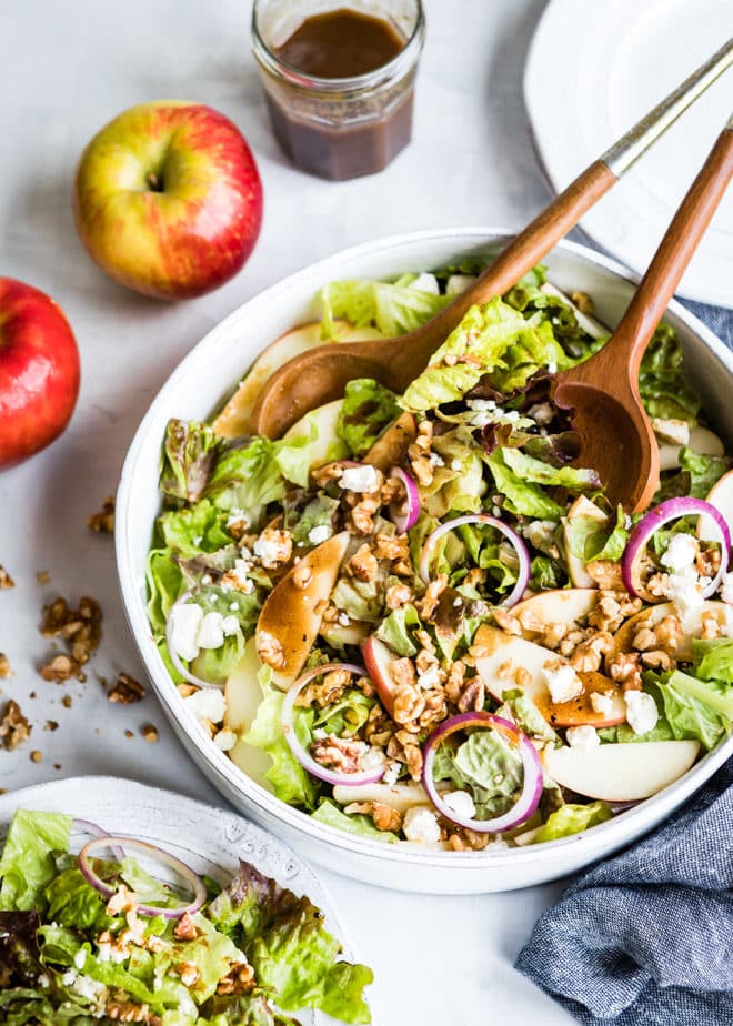An apple walnut salad in a white bowl.