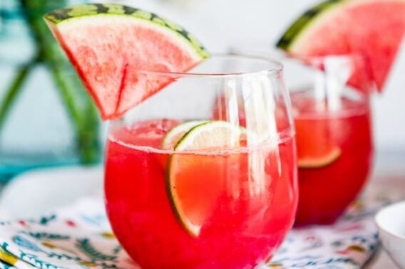Watermelon agua fresca in glasses with wedges of watermelon.
