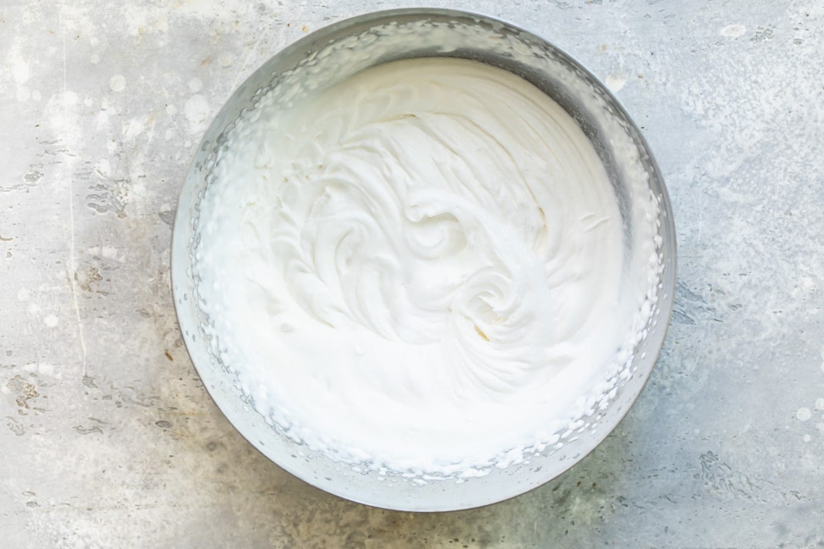 A mixing bowl filled with whipped cream.