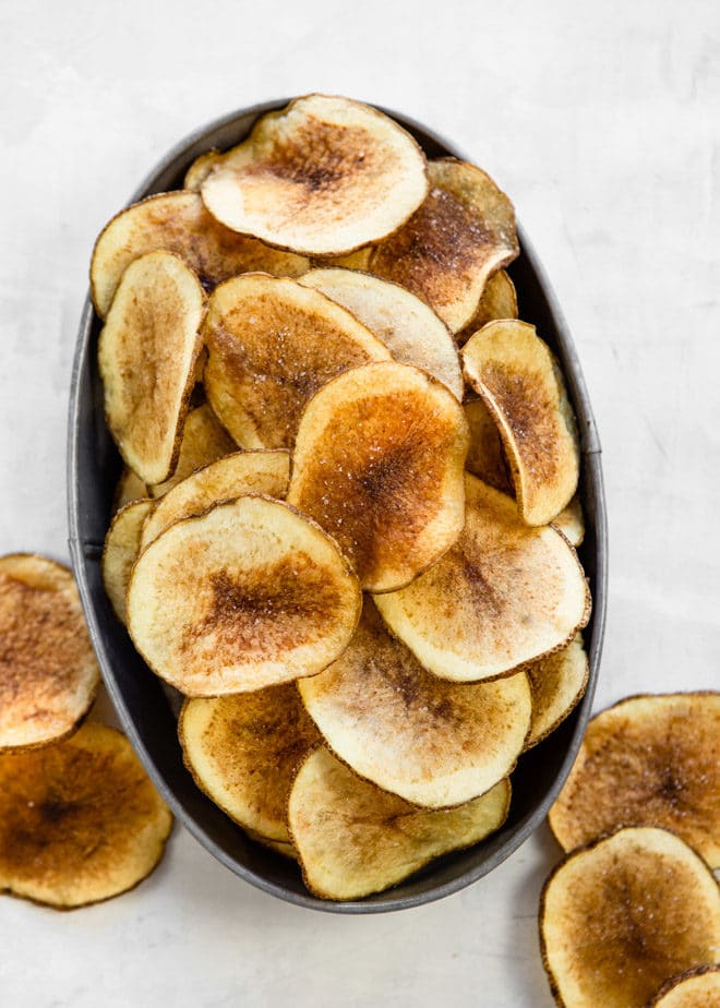 Homemade potato chips in a black oval bowl.