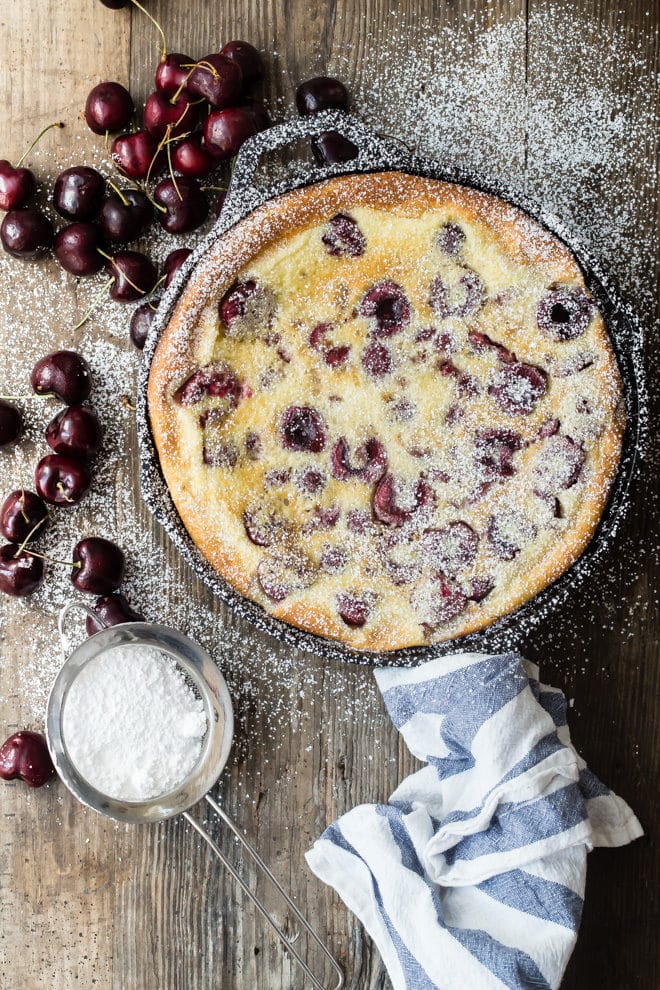 Cherry clafoutis in a black skillet.