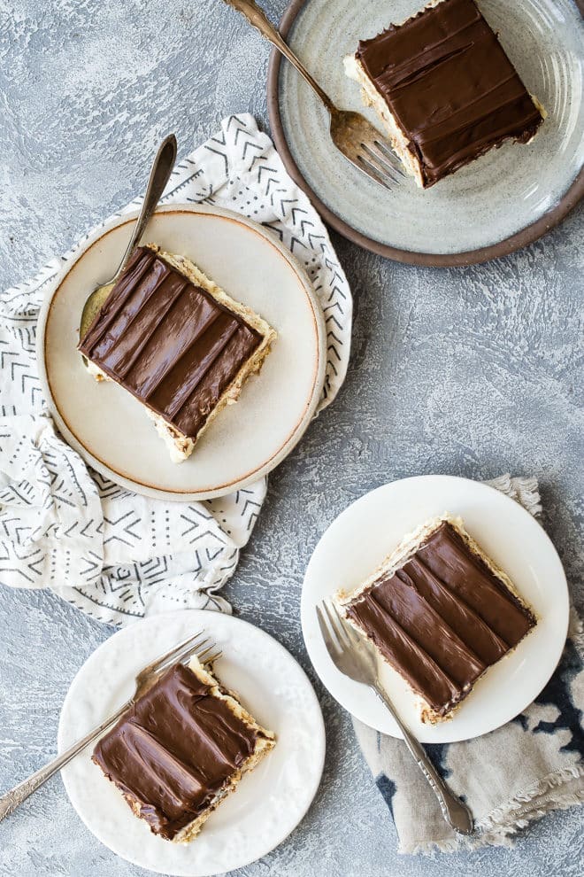 Chocolate eclair cake slices on white plates.