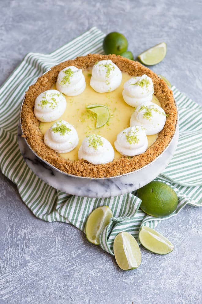 A key lime pie on a striped table linen.