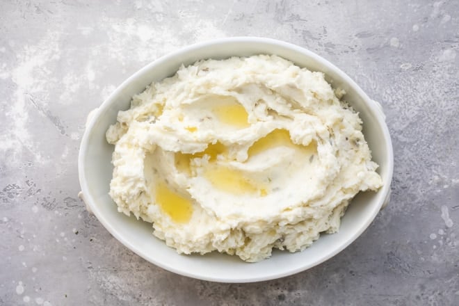 Make ahead mashed potatoes with melted butter in a white serving dish.