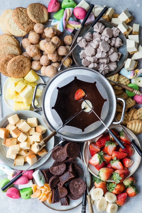 Chocolate fondue served with candy, cookies, cake, and fresh fruit.