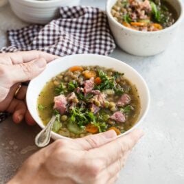 Ham and lentil soup in a white bowl.