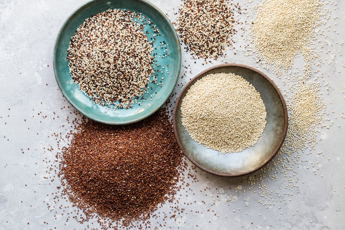 Various types of quinoa on a countertop.