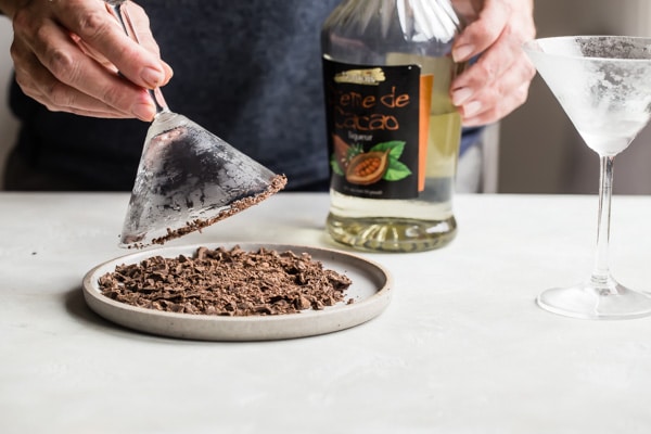 Rimming a martini glass in chocolate shavings.