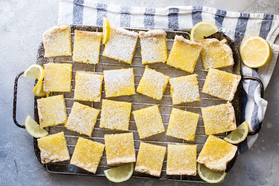 Lemon bars cut into squares on a baking sheet.