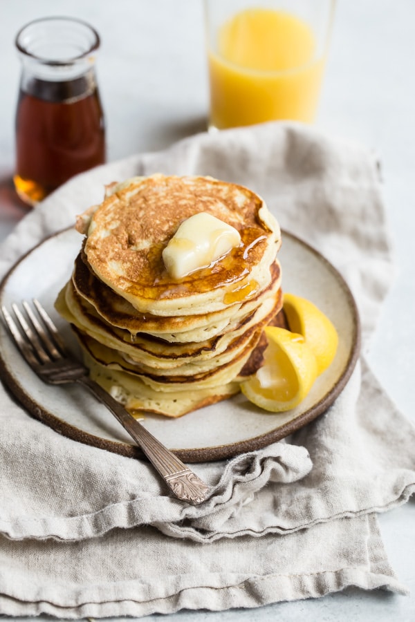 A stack of lemon ricotta pancakes on a plate.