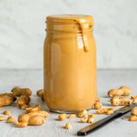 Homemade peanut butter in a clear jar.