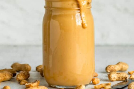 Homemade peanut butter in a clear jar.