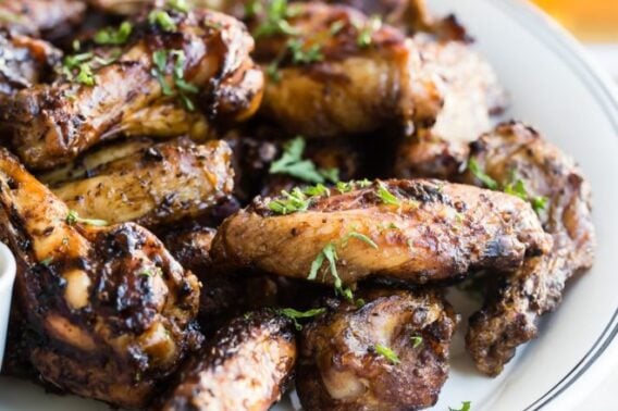 Smoked chicken wings on a white platter.