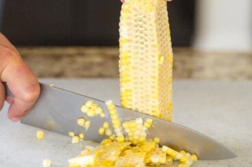 Corn being cut off of a cob.