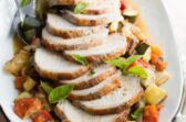 Pork loin with ratatouille on a white platter.
