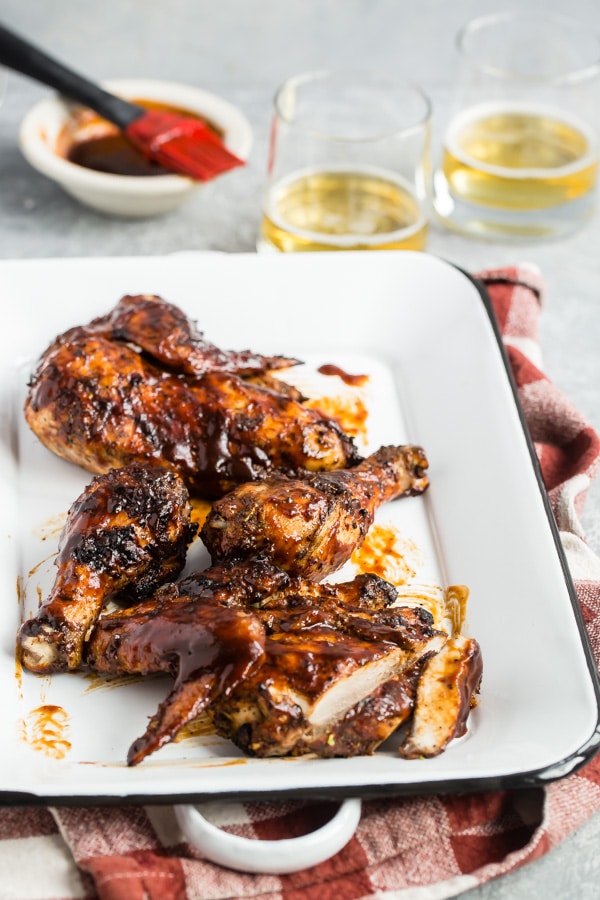 Barbecue chicken on a white rectangular platter.