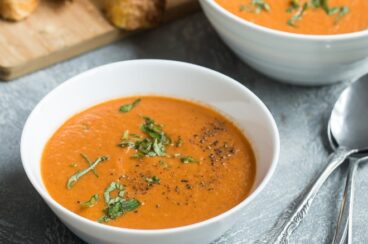 Roasted tomato soup in white bowls.