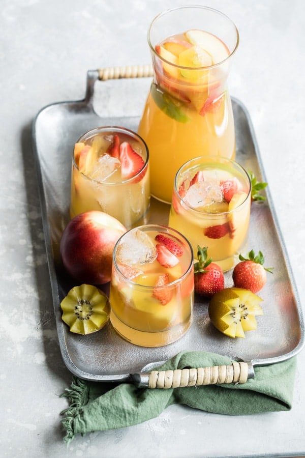 Passion Fruit and Pineapple Sangria whisks you away to the tropics with one sweet sip. The perfect signature drink for your next party, shower, or brunch!