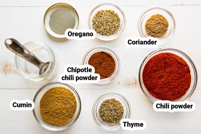 Homemade chili seasoning ingredients in various clear bowls.