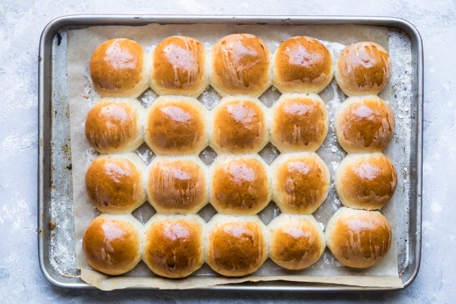 Baked soft yeast dinner rolls on a baking sheet.
