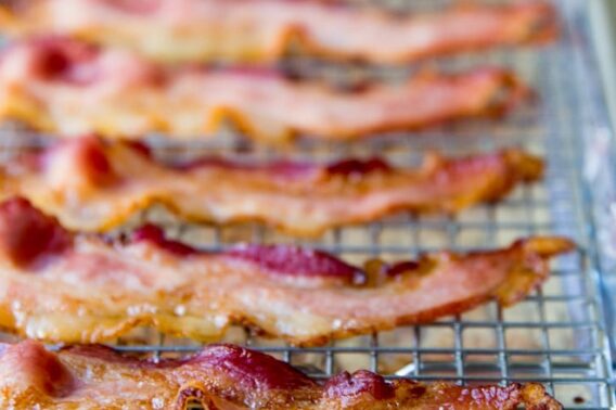 Cooked bacon strips on a baking sheet.