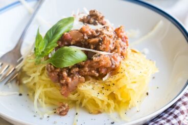 Spaghetti squash with homemade meat sauce on a white plate.