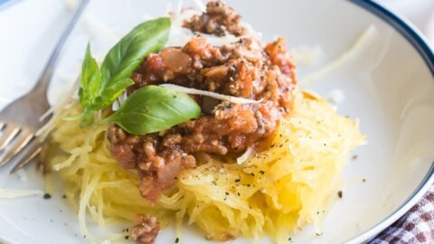 Spaghetti squash with homemade meat sauce on a white plate.
