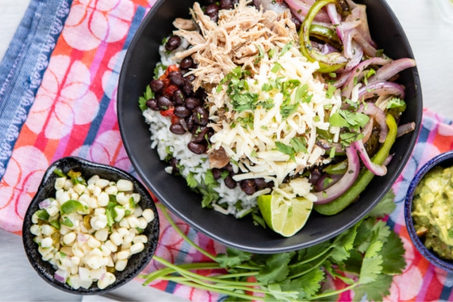 An overhead shot of chipotle carnitas in a black bowl.