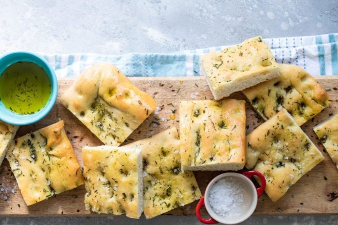 Focaccia pieces on a wooden cutting board.