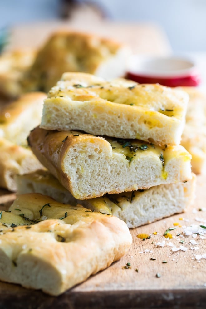 Focaccia pieces on a wooden cutting board.