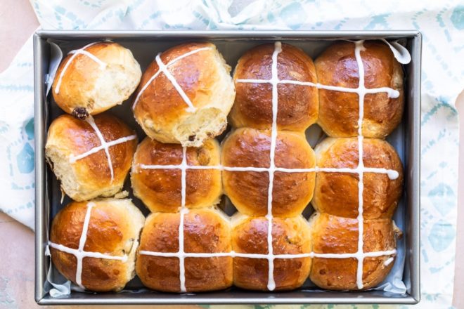 Hot cross buns in a silver baking pan.