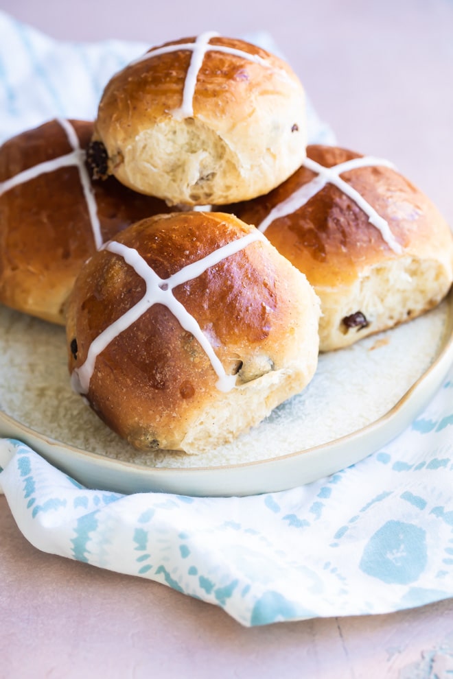 Hot cross buns on a white plate.