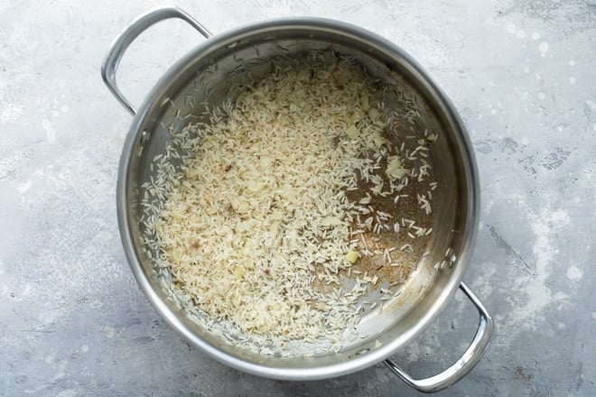 Uncooked rice in a silver pot.