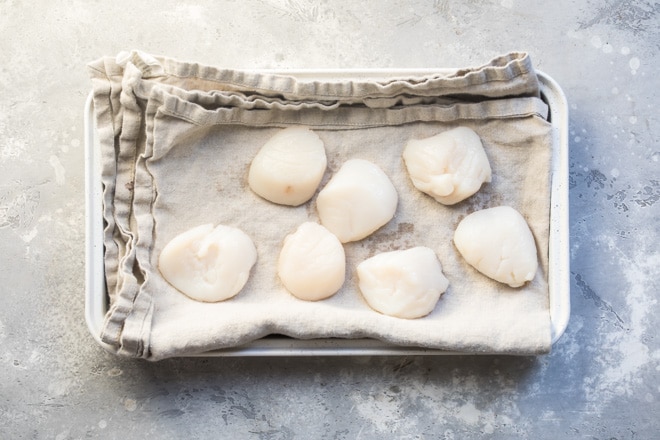 Scallops being dried on a tan towel.