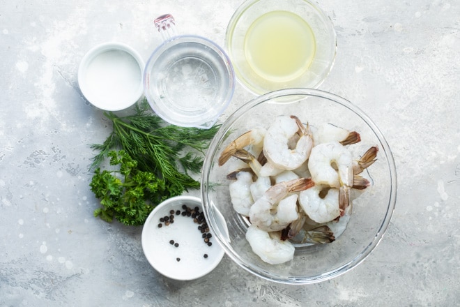 Shrimp salad ingredients in various bowls.